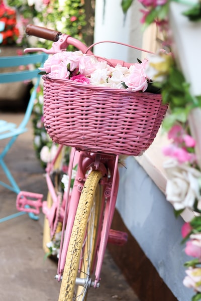 粉色和白色的花在粉色编织的篮子里